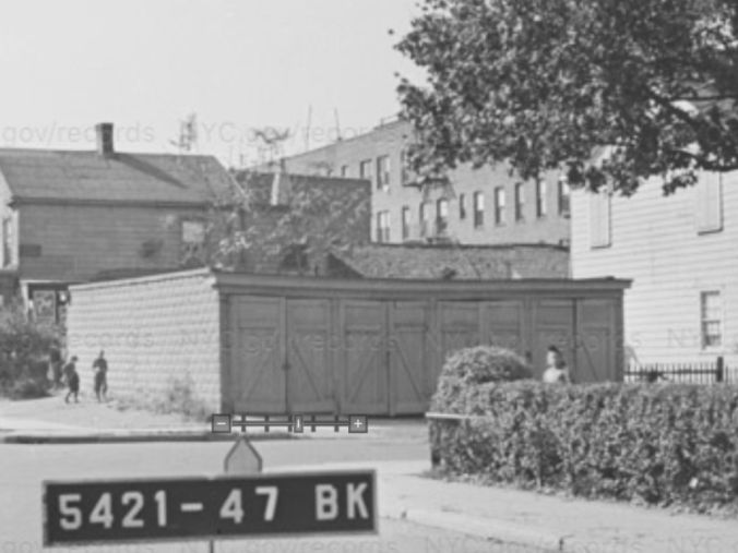 Black and white surveying photo of a large wooden garage on a residential street
